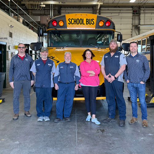 Amy Eaton is pictured with some of the team behind the school system's propane-fueled buses