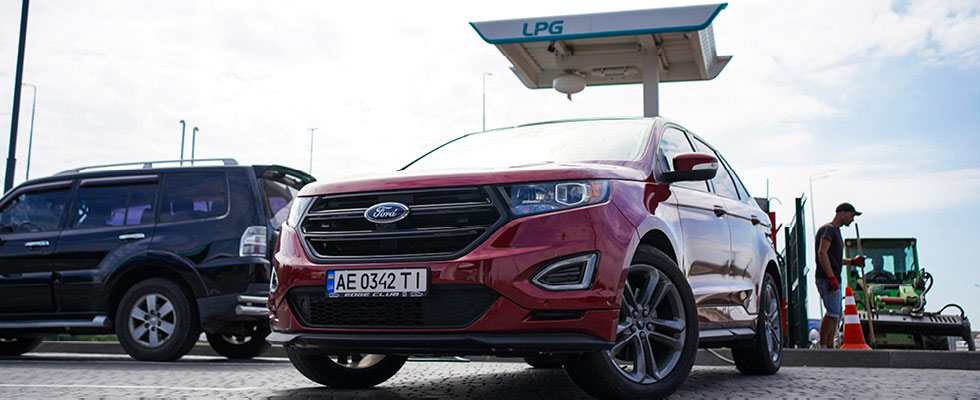 An autogas-fueled Ukrainian vehicle is depicted parked in front of an LPG fueling station.