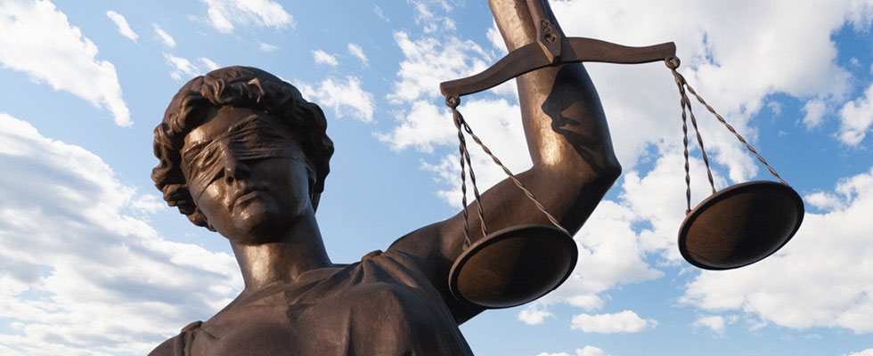 A picture depicts a statue of "lady justice" blindfolded and holding the measuring scales.
