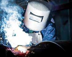 A welder in protective face covering