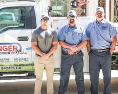 Four Conger LP Gas team members stand in front of a Conger truck for a photo