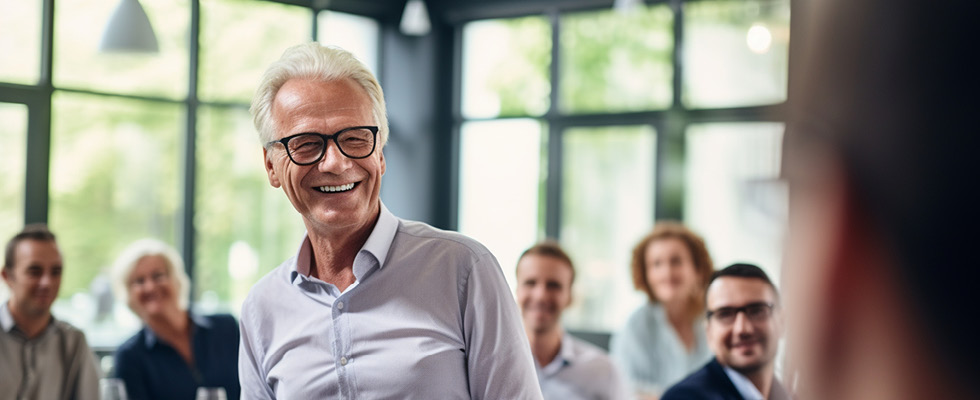 An elderly business man is pictured smiling.