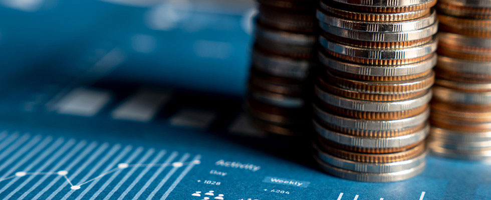 Three stacks of coins on paper with graphs on it.