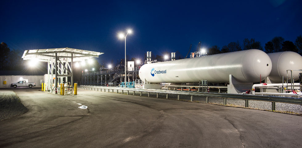 White Crestwood propane storage tanks sit on the company lot against a night-sky background.