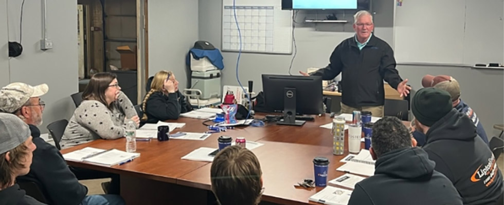 John Horner leads a safety training event with trainees seated around a table