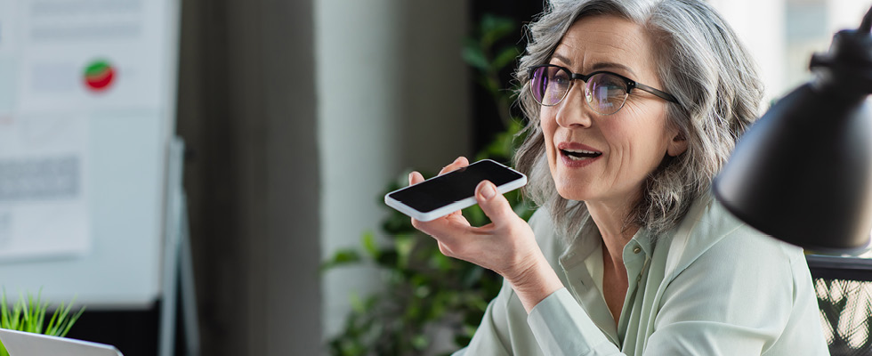 A woman uses speakerphone to talk on her smart phone