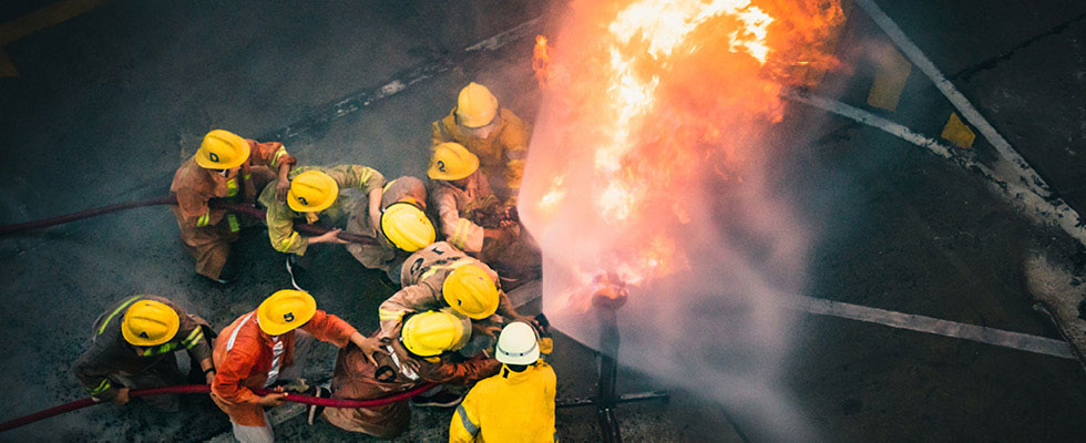 Firefighters are pictured using fire hoses to fight off a growing flame.