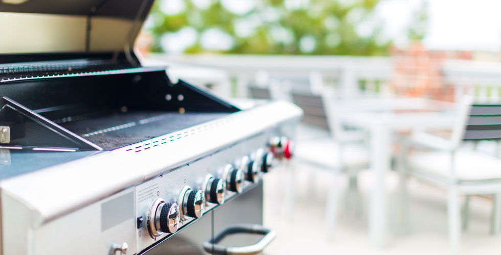 Propane-powered grill sitting on an outdoor patio