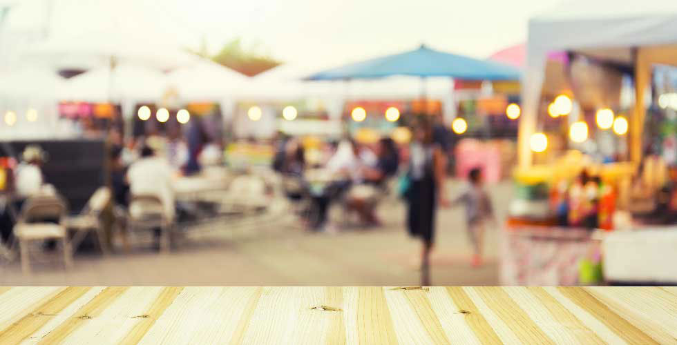 An out of focus image of people at a block party or farmer's market outdoor event