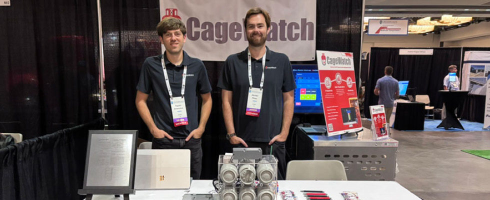 The founders of CageWatch, a company boosting current forklift propane cage technology, pose at their booth at a propane event.
