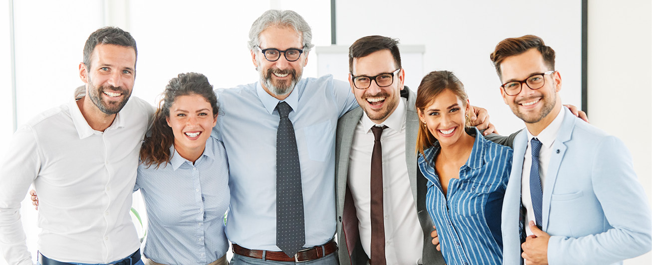 Business employees stand, smiling, symbolizing a successful M&A transaction.