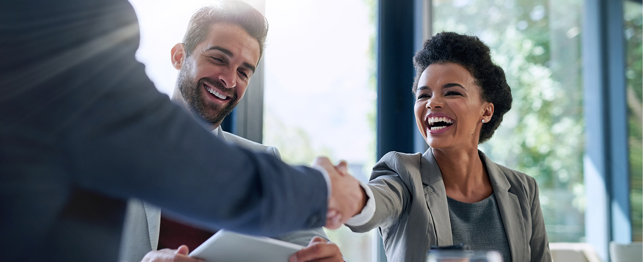 A businesswomen reaches out to shake hands while smiling, symbolizing a healthy fractional relationship.