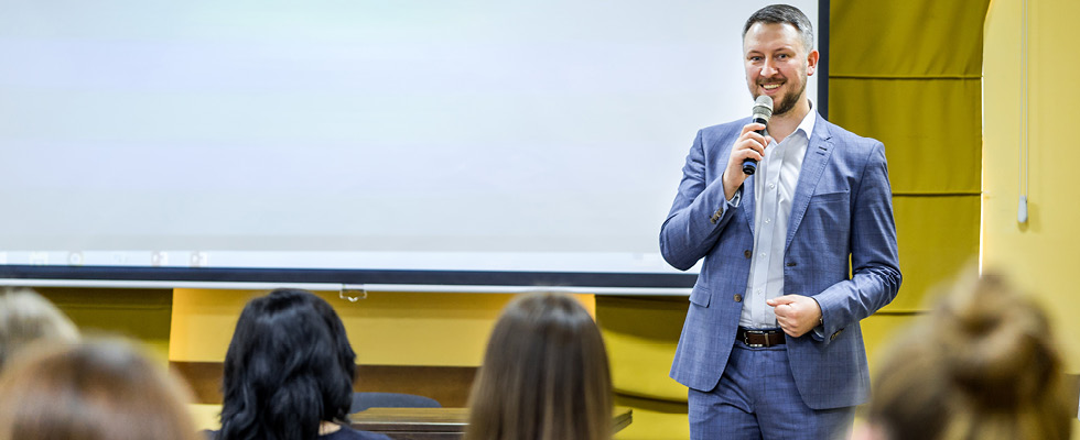 A man is standing in front of an audience giving a speech