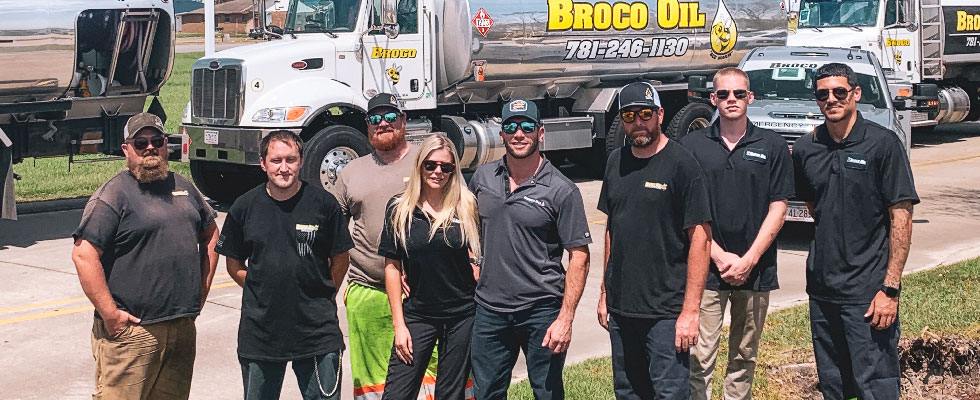 Robert and Angela Brown stand with other members of the Broco Oil team in front of a silver Broco Oil propane truck.