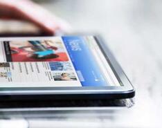 A person browses a news website on a tablet