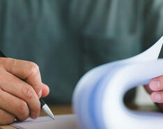 A man fills out and signs a series of forms