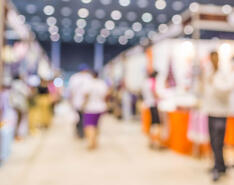 Blurred photo of people visiting booths at a trade show